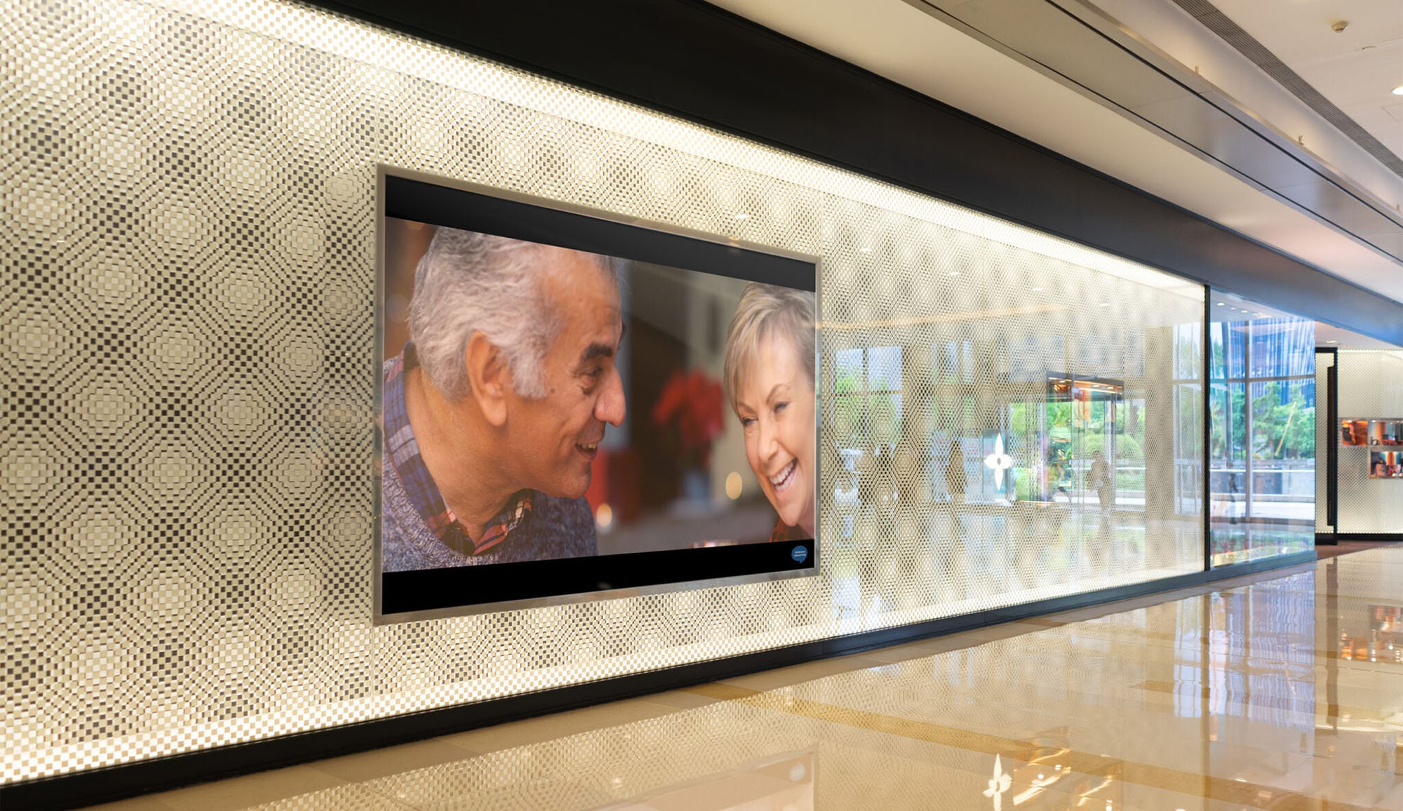 Hidden Hearing campaign photography — Life Is Worth Hearing film playing on a screen in a Hidden Hearing office