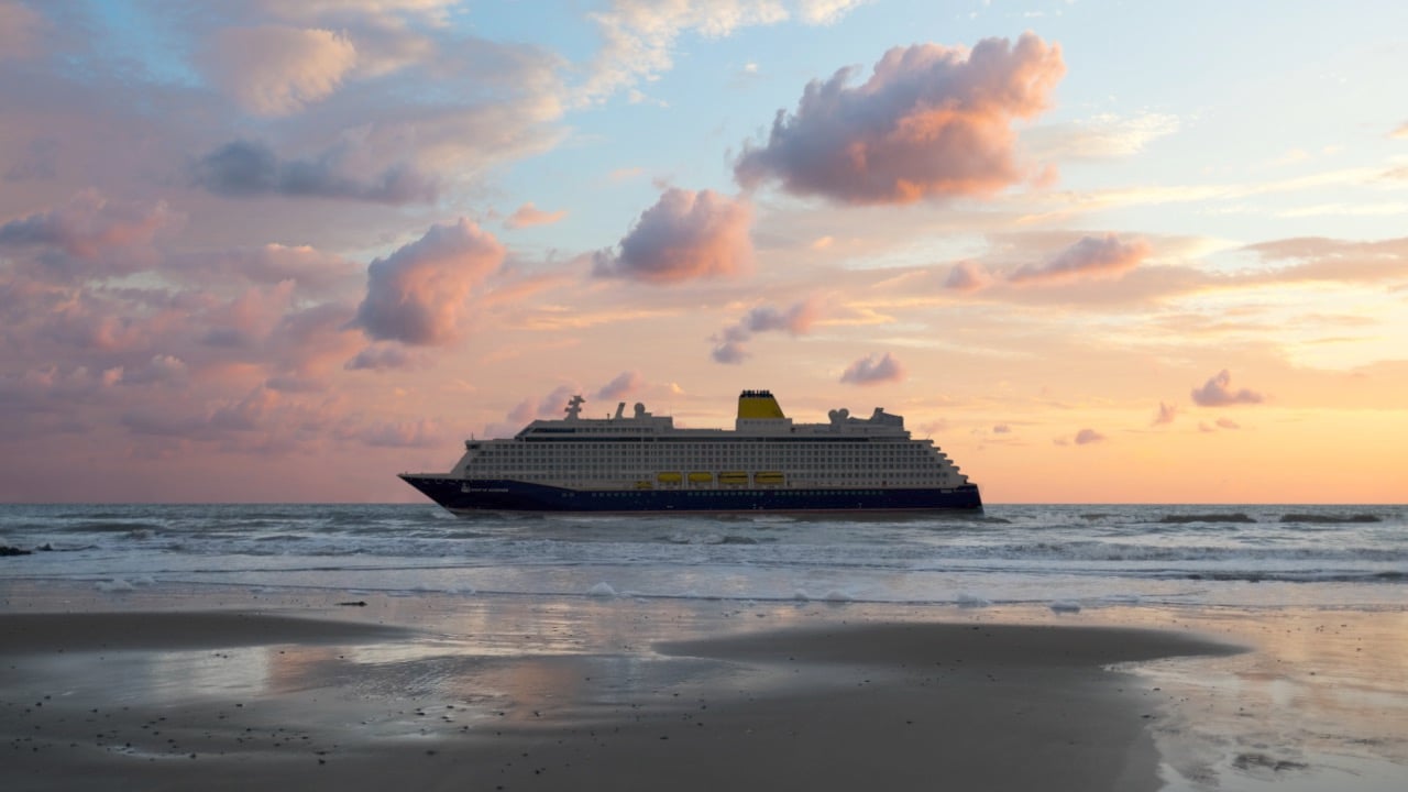 Saga cruise photography — Spirit of Discovery cruise ship at sunset reflected on a wet shoreline