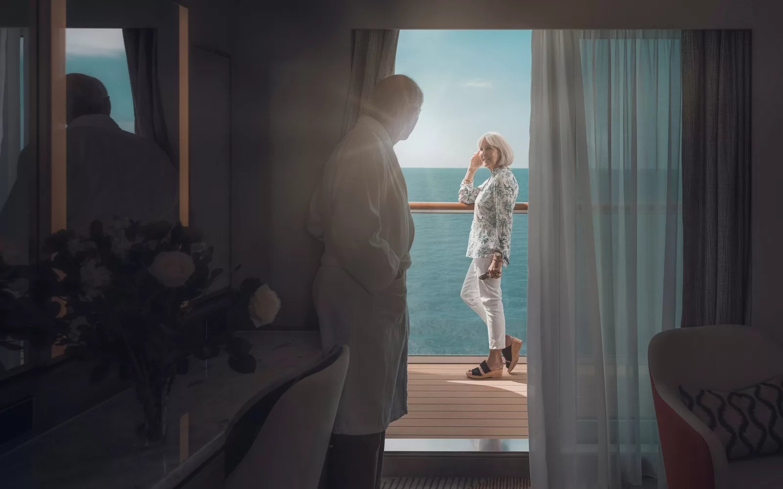 Saga cruise stateroom photography — couple on a sunlit private balcony with open ocean view