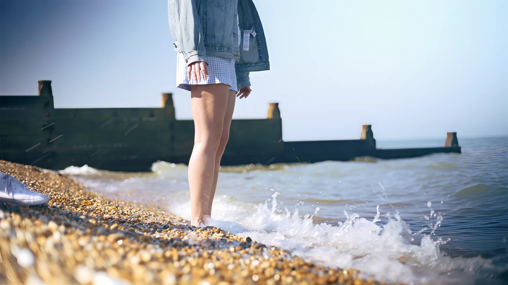 Visit Kent tourism photography — close-up of bare feet paddling at the water's edge by the groynes