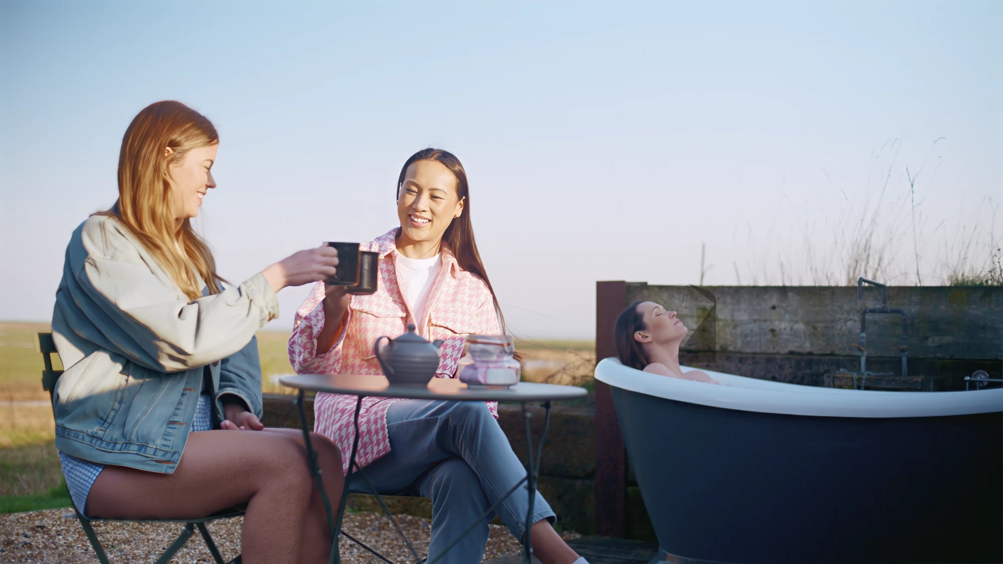 Visit Kent tourism photography — friends sharing a toast at an outdoor spa table by the coast